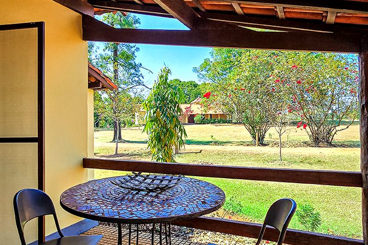 Mesa na varanda do Chalé 12 com vista para o gramado