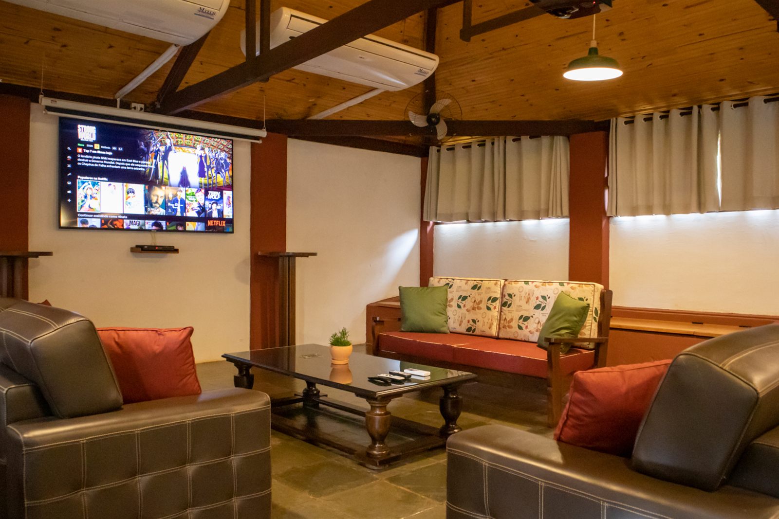 Sala de TV com sofás de couro e mesa de centro