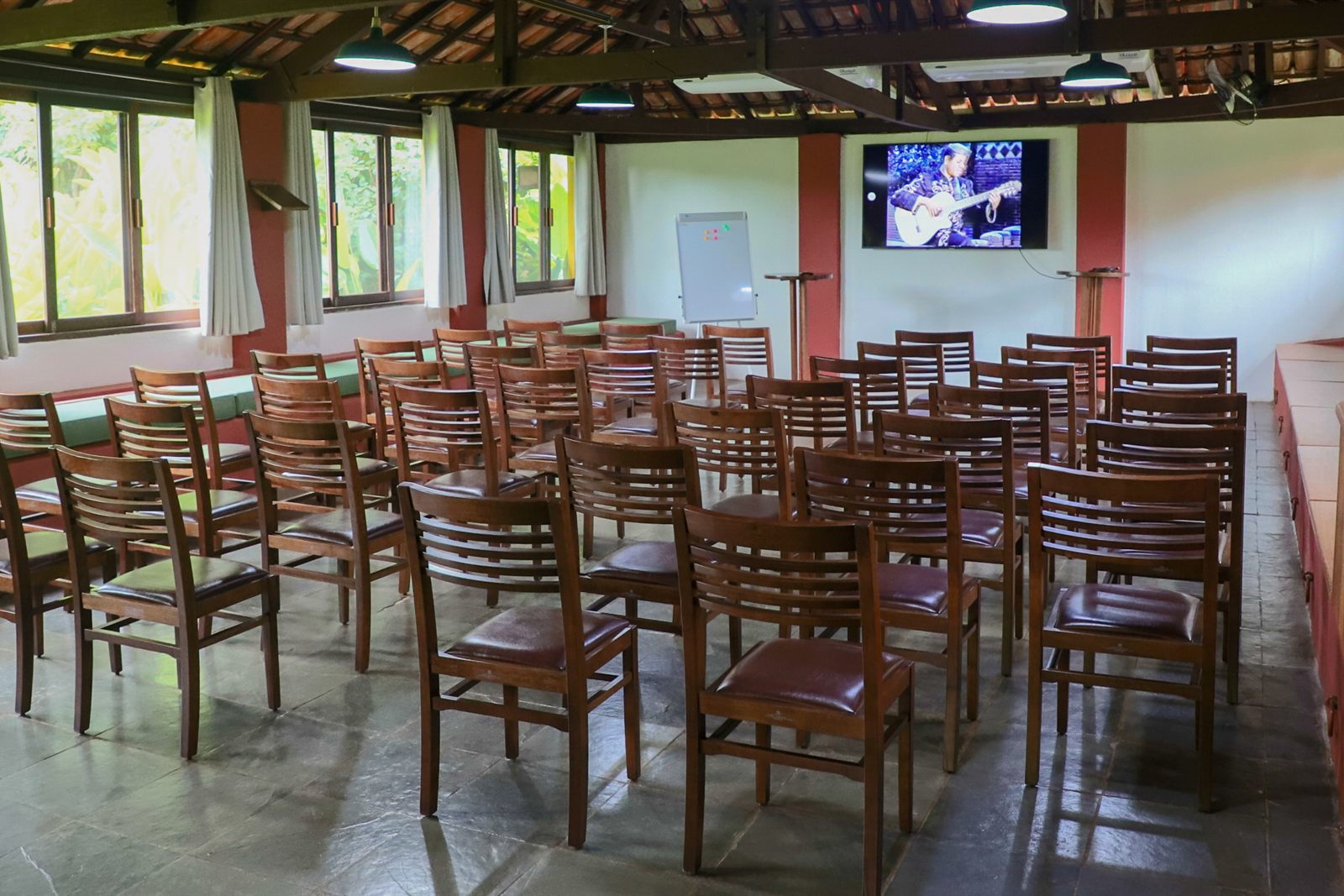 Salão montado em auditório, com cadeiras e TV