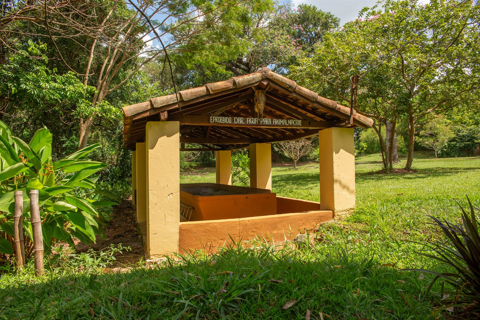 O tanque comunitário visto de lado, com a placa na viga